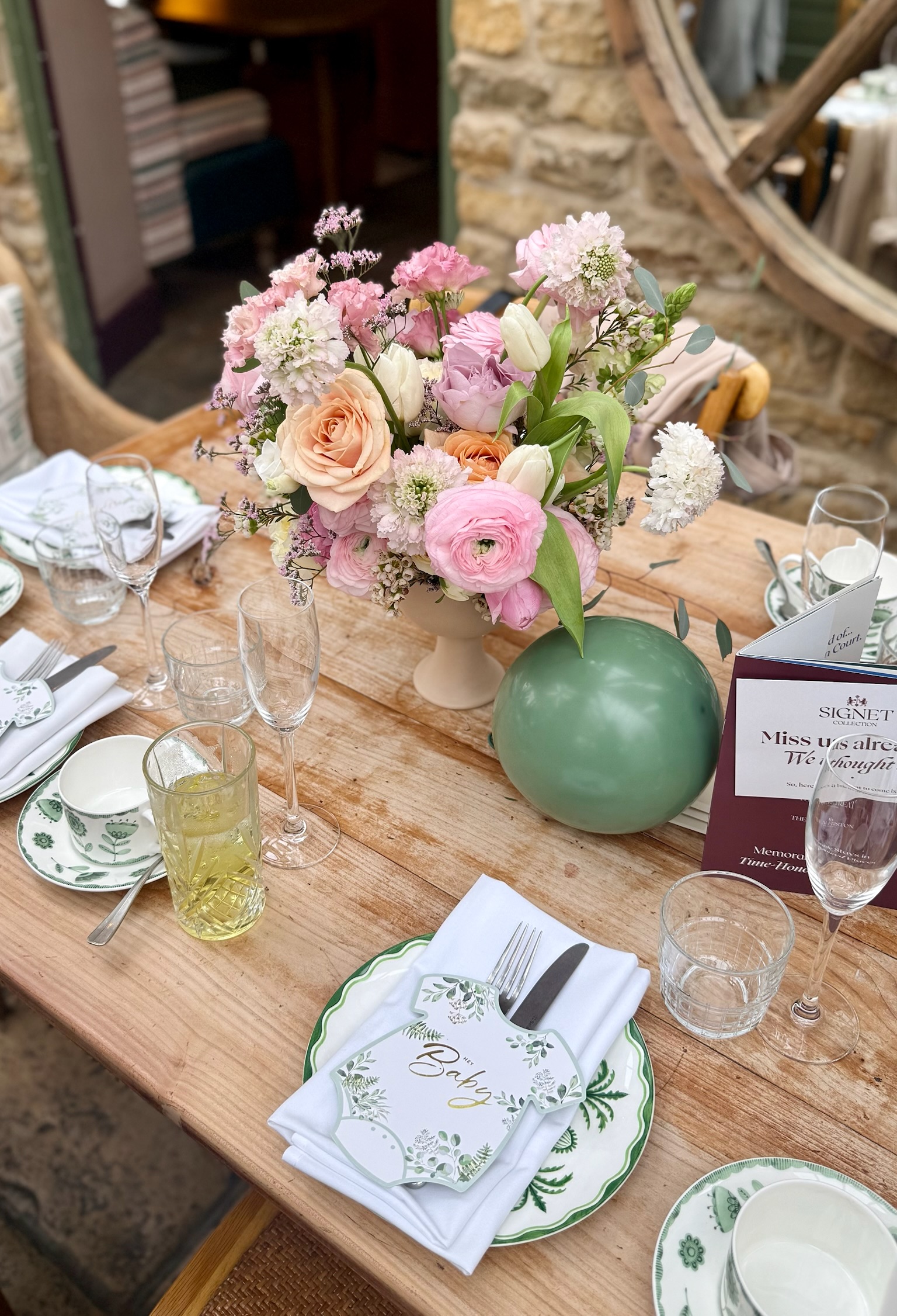A spring table setting with pastel flowers in a ceramic vase