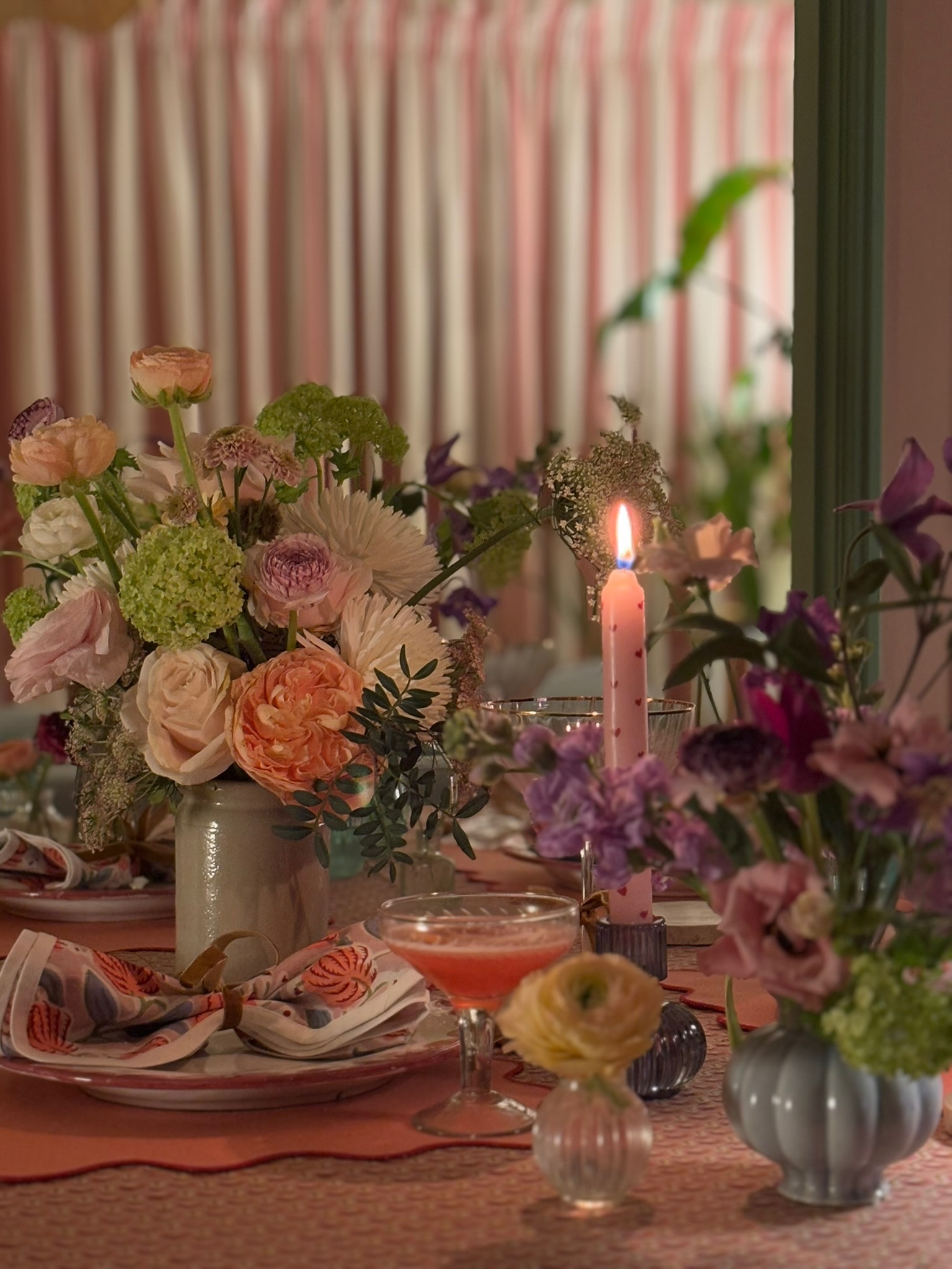 An intimate candlelit dinner table with abundant floral arrangements